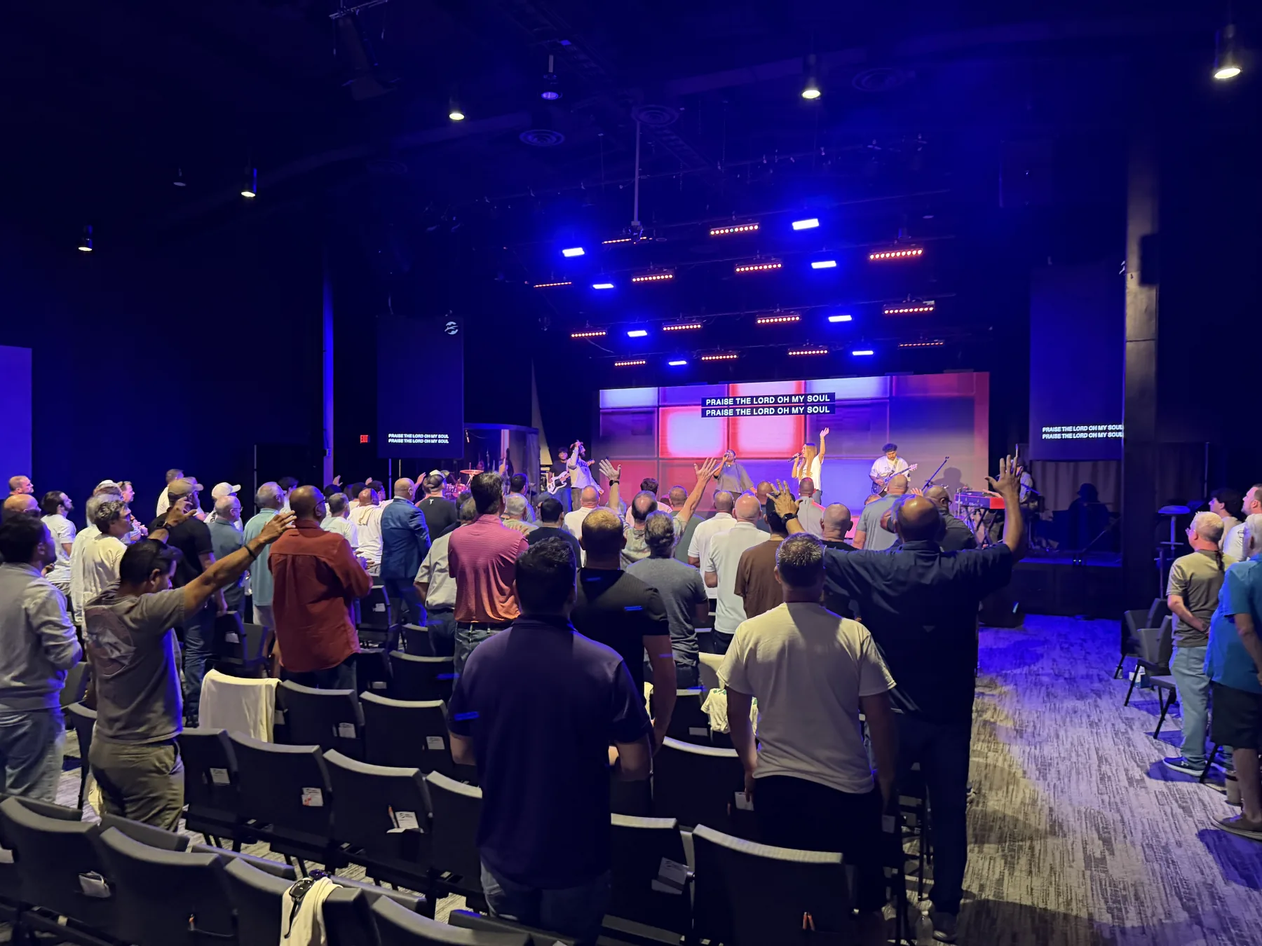 A wide view of men gathered in the Oaks Church auditorium during Forge One Day worship