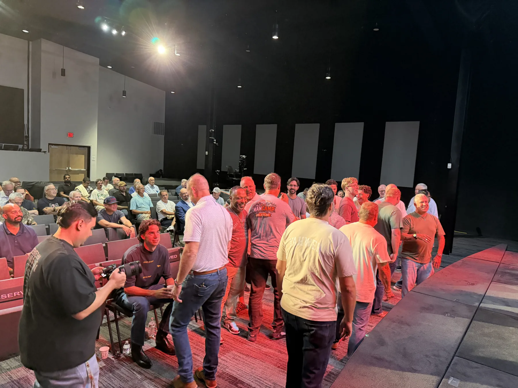 Men gather beside the stage during one of the morning activities