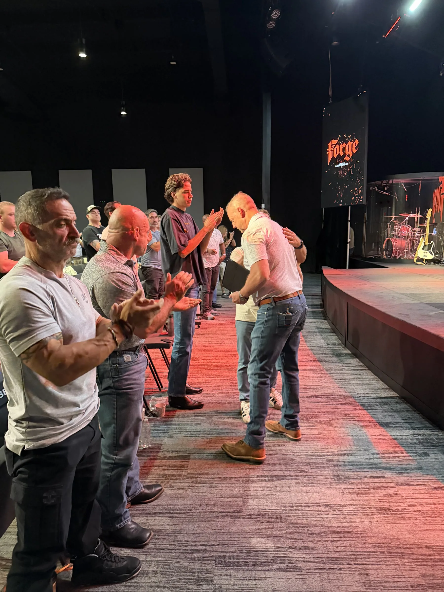 Men respond together at the front of the Forge One Day stage
