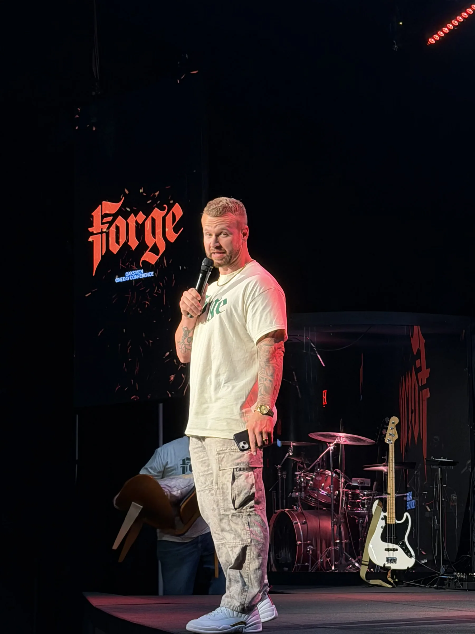 A speaker addresses the room beneath the Forge logo