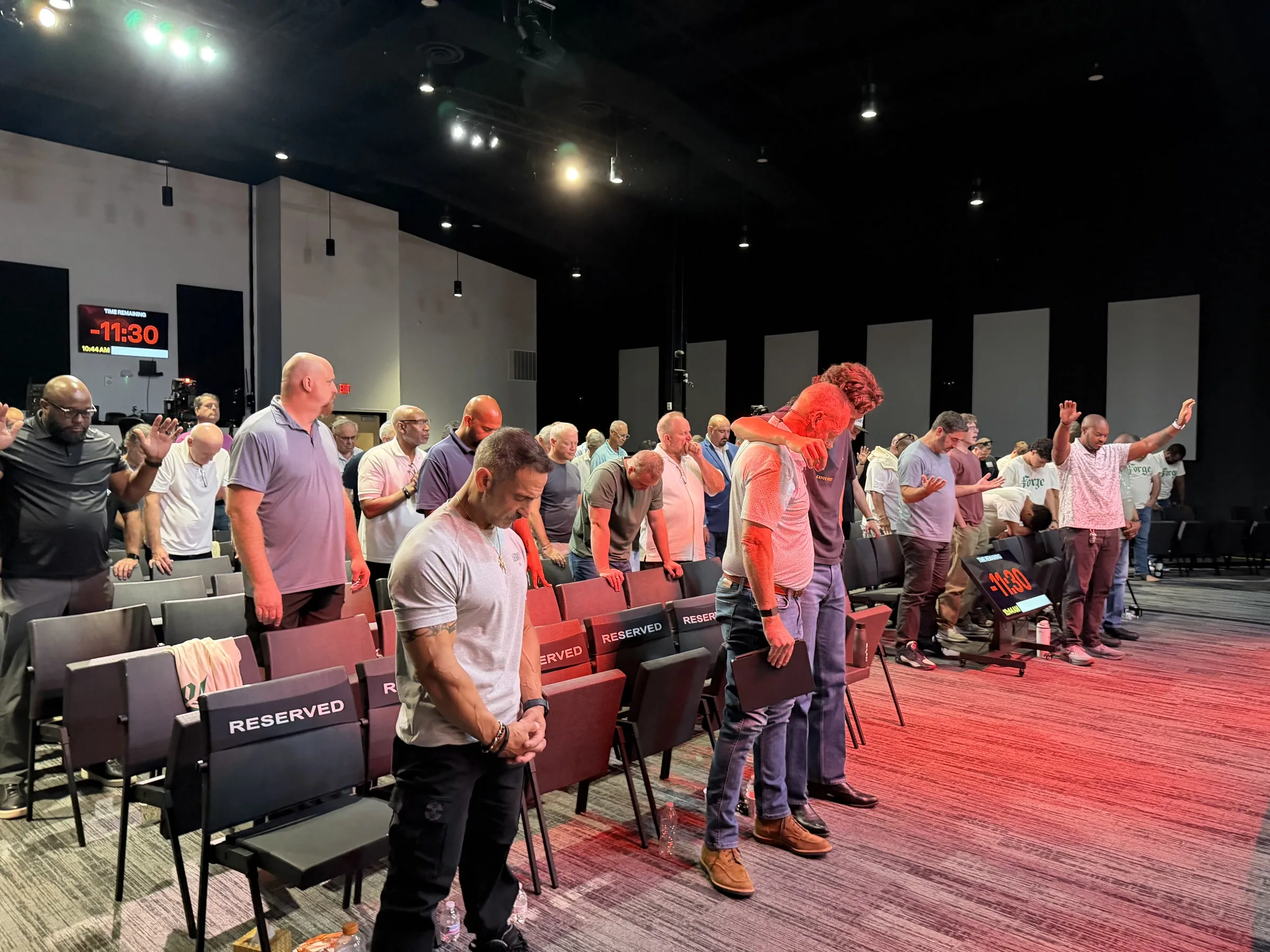 Men stand throughout the auditorium during a Forge One Day session